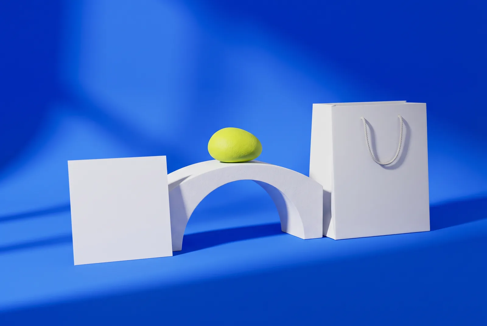 A white card and a shopping bag joined by a small white bridge on a cobalt blue backdrop, showing how a QR code can bring more customers from print to store.