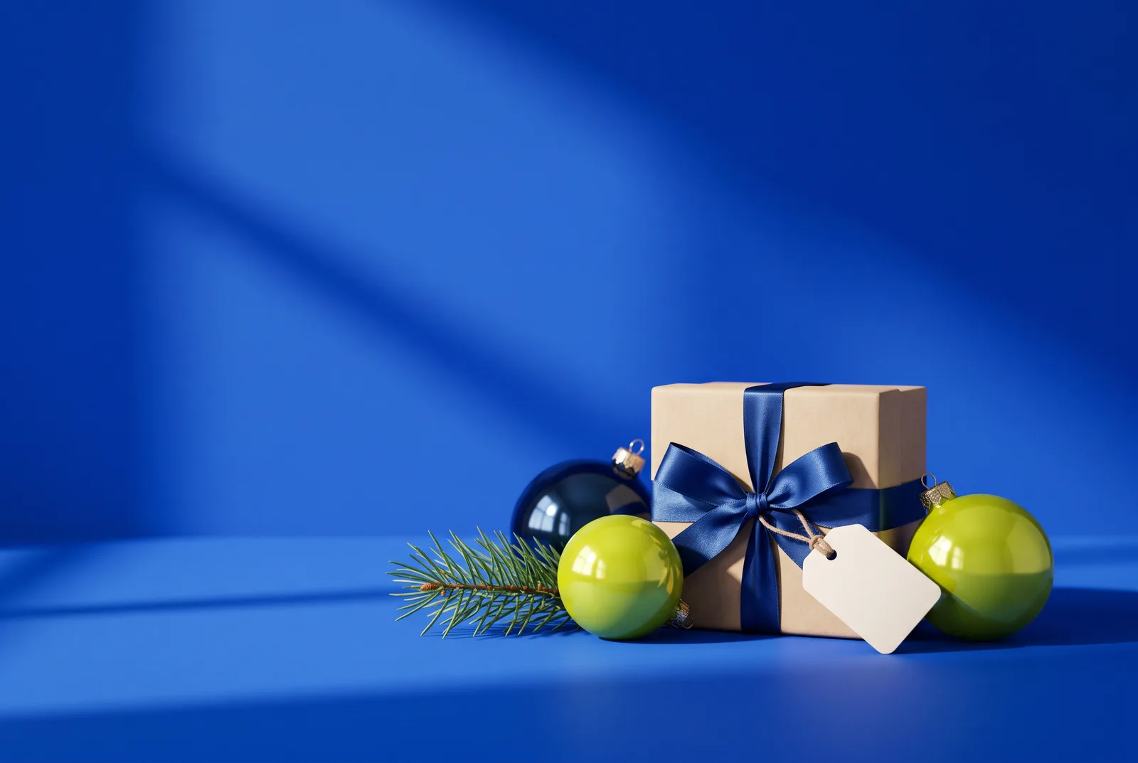 Christmas QR code ideas for shops: a wrapped gift with a blue ribbon, glossy lime and navy baubles, a pine sprig and a blank gift tag on cobalt blue.