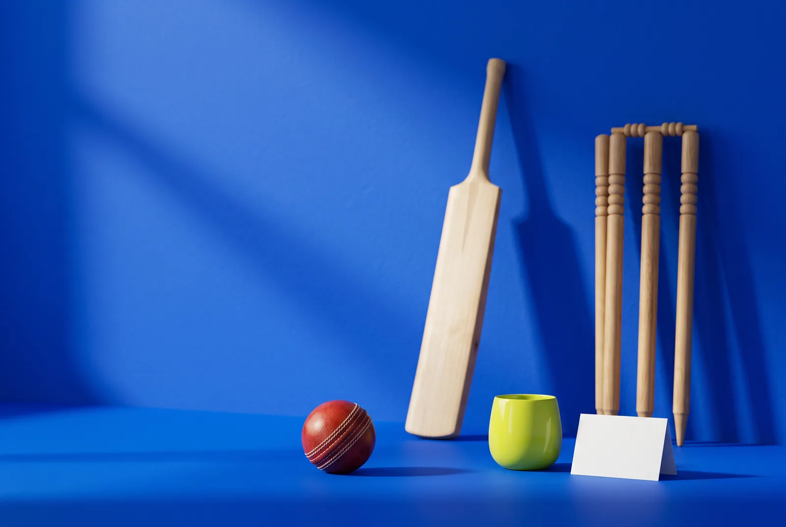 Match-day QR code ideas for restaurants: a red cricket ball, a willow bat, wooden stumps and a lime tumbler beside a blank table card on cobalt blue.